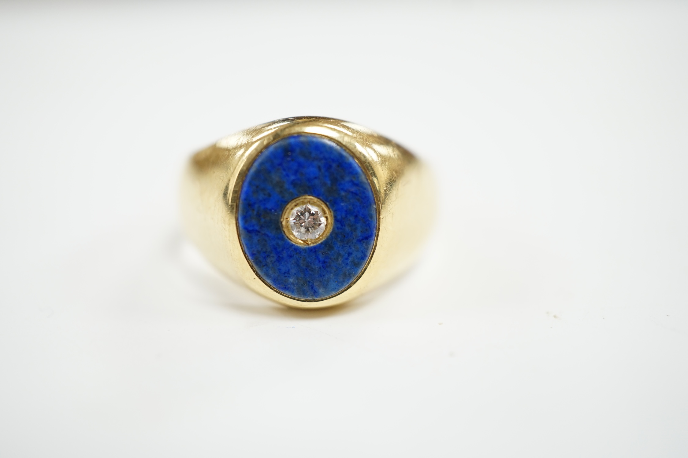 A mid to late 20th century Italian 750 yellow metal and oval lapis lazuli set signet ring, with inset diamond, size U, gross weight 12 grams.